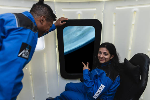 Two commercial space travelers looking at the earth through the window of a spaceship.